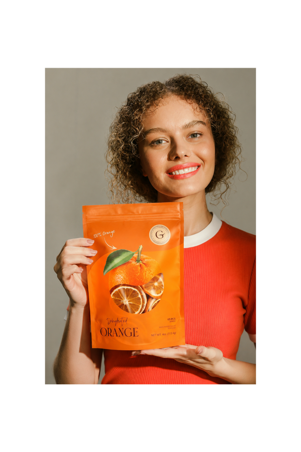 Woman holding dehydrated orange to cocktail garnish bag for old fashioned, whiskey and craft cocktails